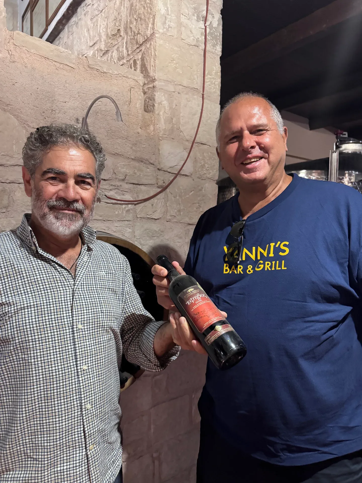 Nikos and Yanni in the cellar holding a bottle from 2004, Fragospito’s first vintage