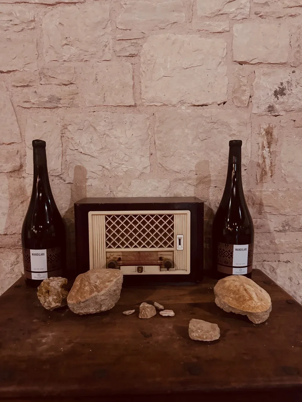 An old radio between two Mandilari bottles and stones