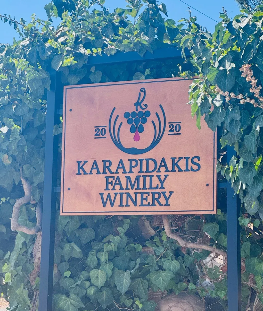 Karapidakis Family Winery sign surrounded by vines
