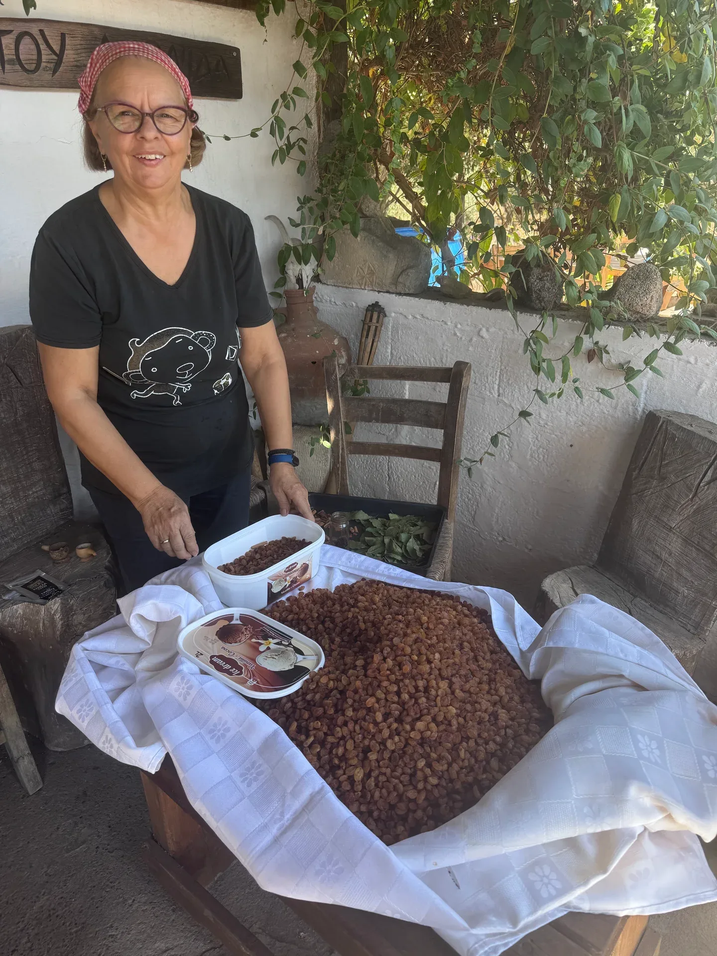 A woman beside trays of sultana raisins and bay leaves
