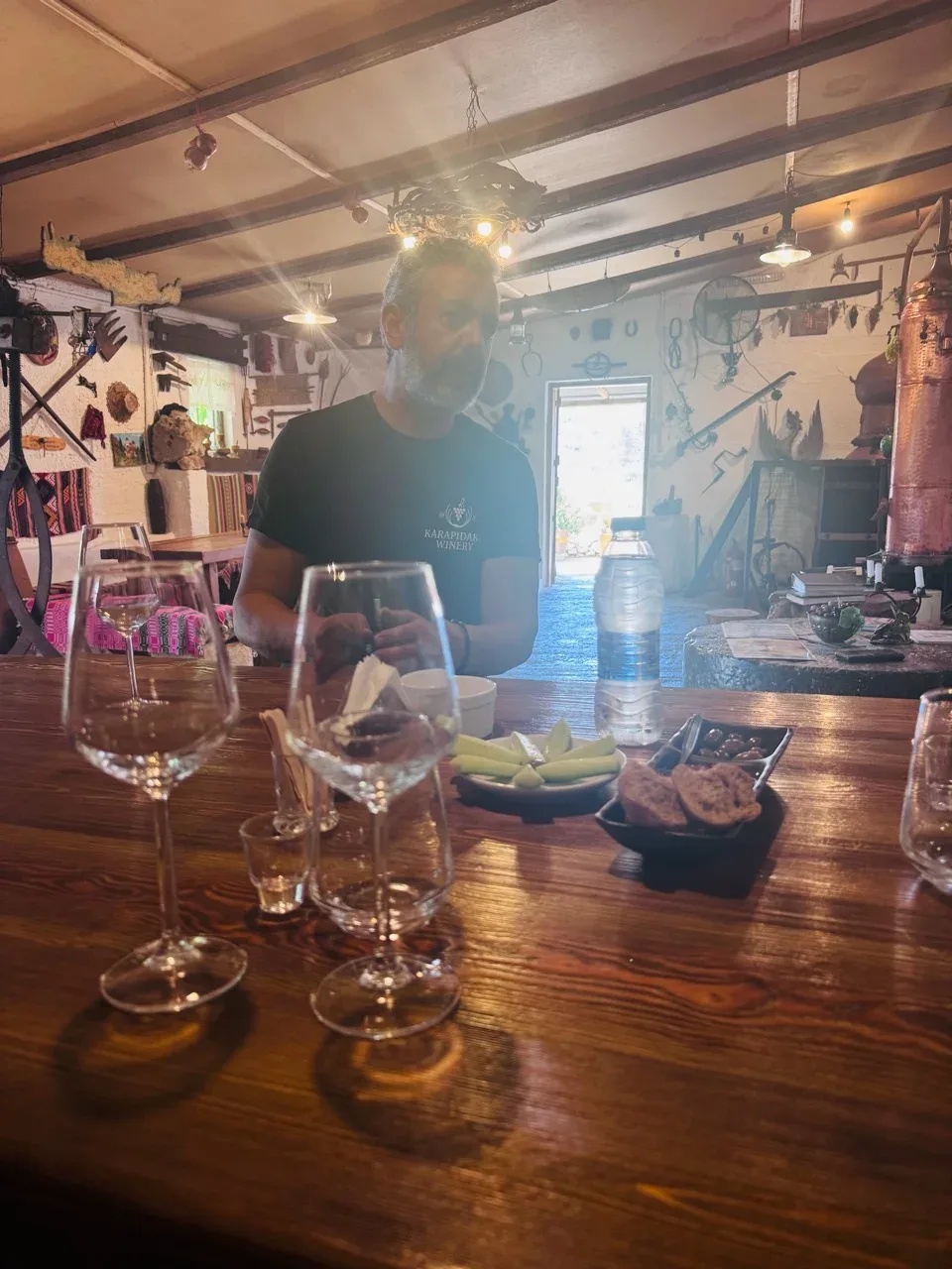 A Karapidakis host seated at the tasting table with wine and Cretan snacks