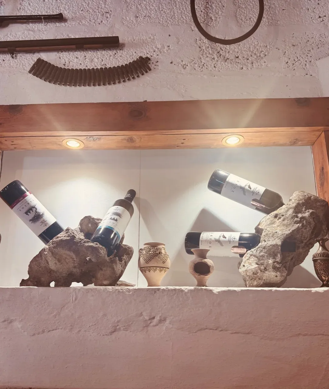 ISKIOS wine bottles displayed among rocks and traditional objects