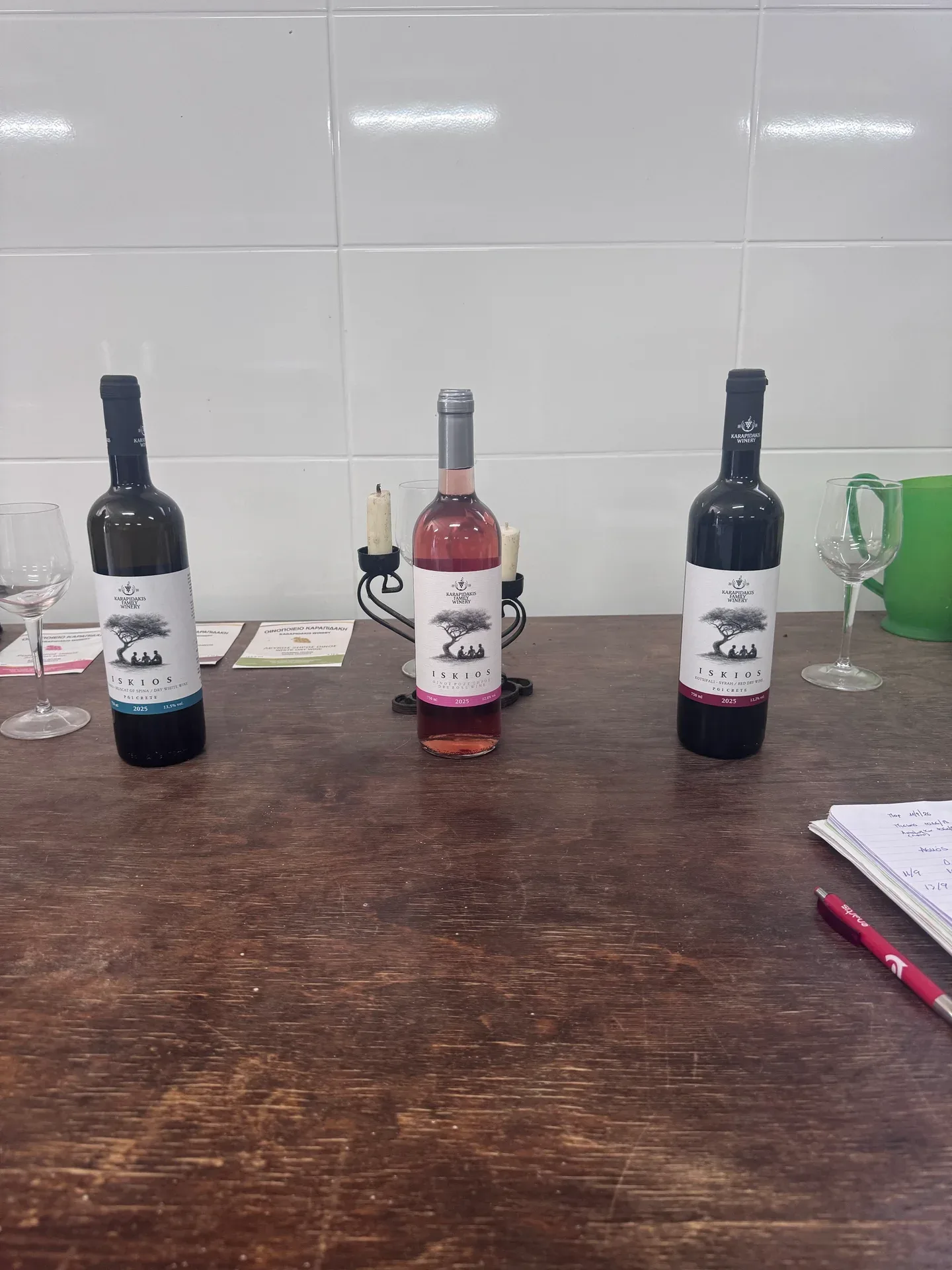 Three ISKIOS wines arranged on the tasting table: white, rosé and red
